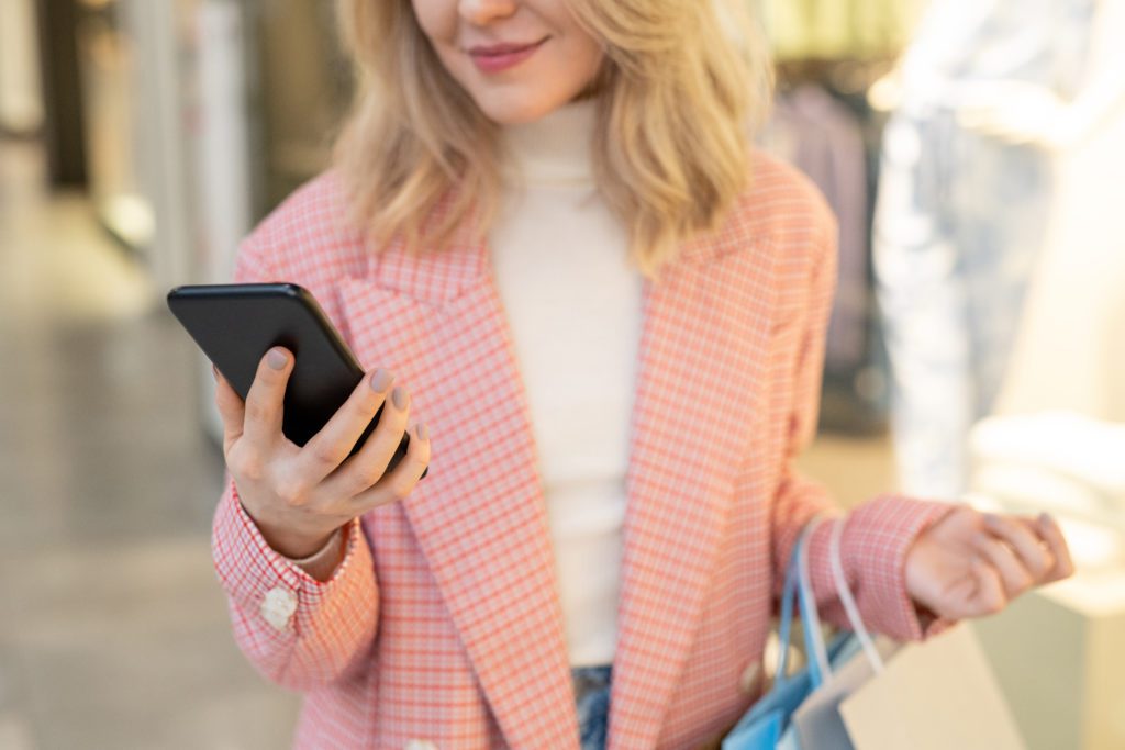 A woman holding a phone while watching video