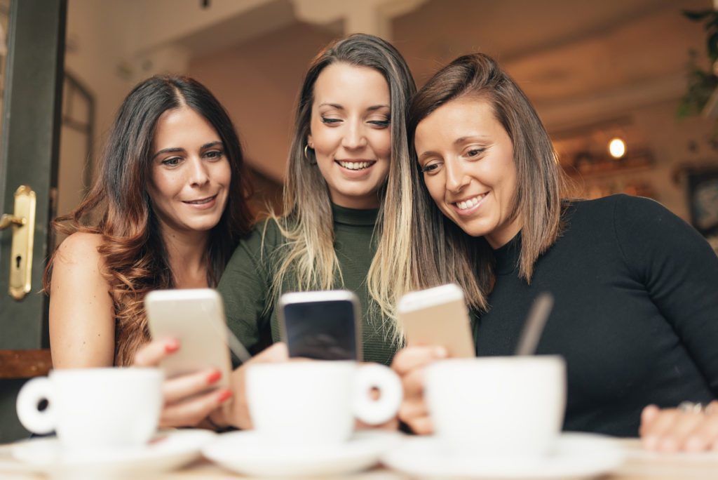 Friends watching social media in a smart phone.